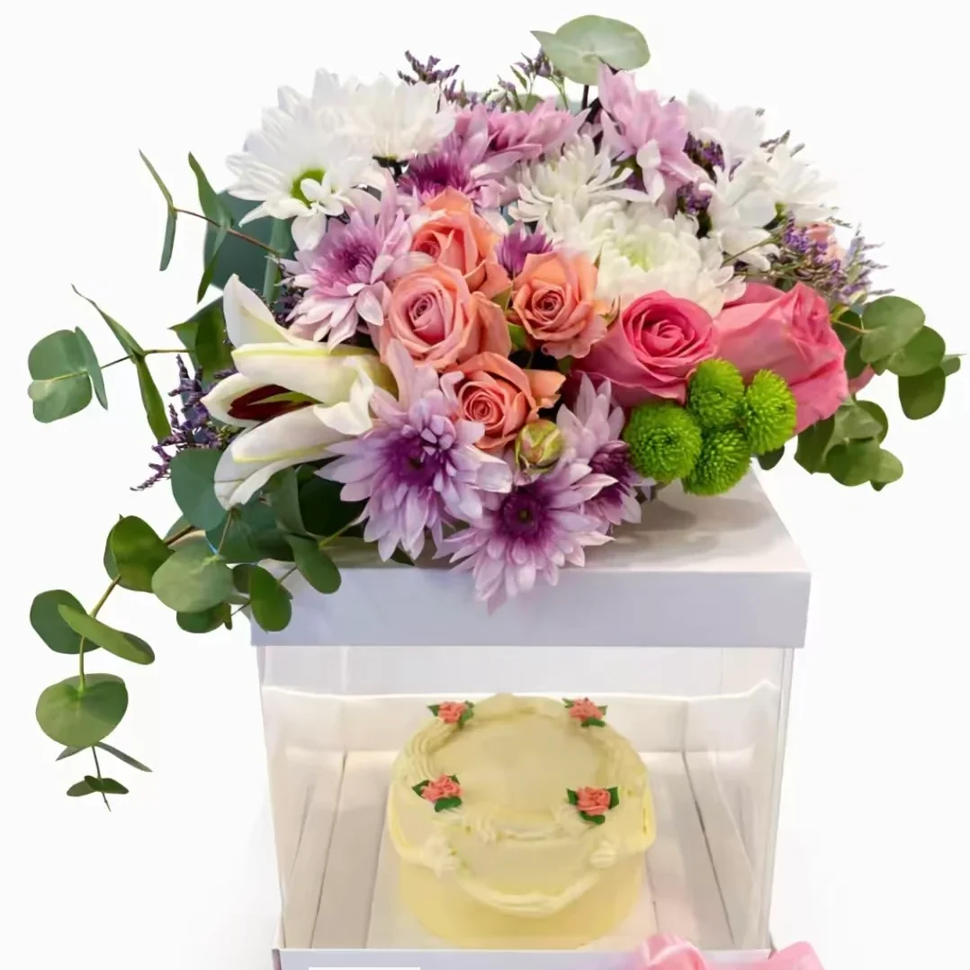 صندوق السحر - بوكس شفاف داخله كيك مع زهور الجوري مع كازابلانكا والاقحوان ولمسات من أوراق الأوكالبتوس